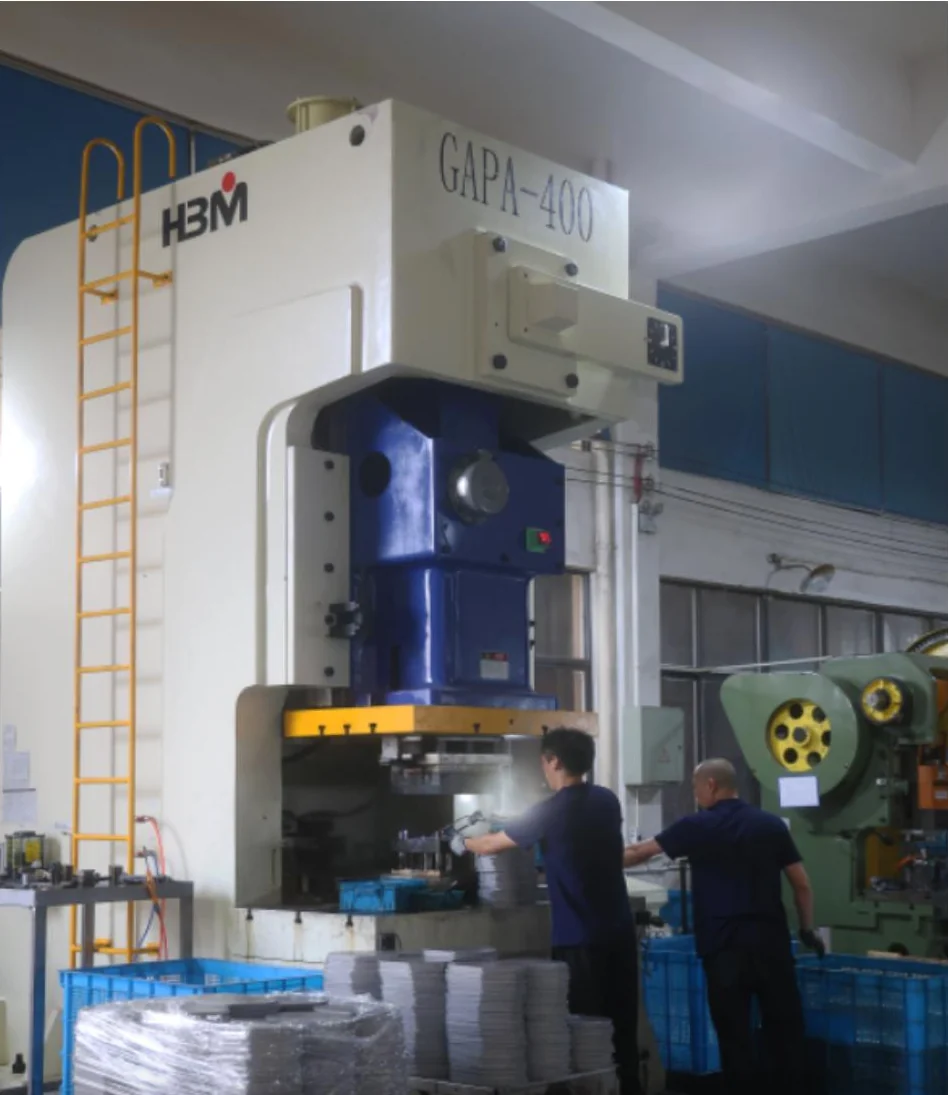 Operators working beside a hydraulic press in the metal workshop