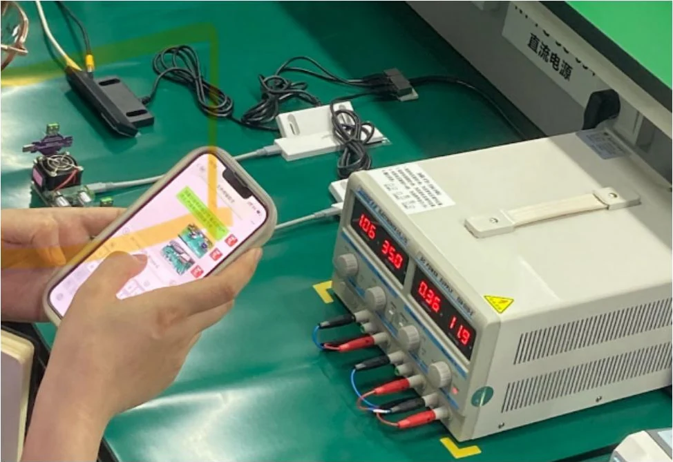 Handset undergoing an electronic load test on a workbench