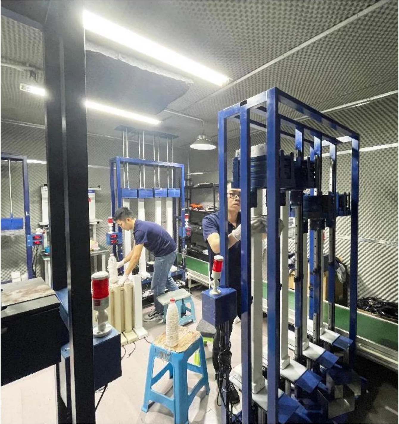NATE staff working with test equipment inside the soundproof room
